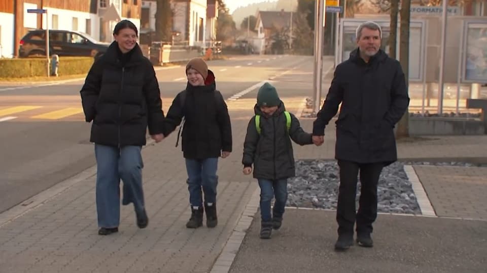 Schulkinder – begleitet von Erwachsenen – auf dem Schulweg.