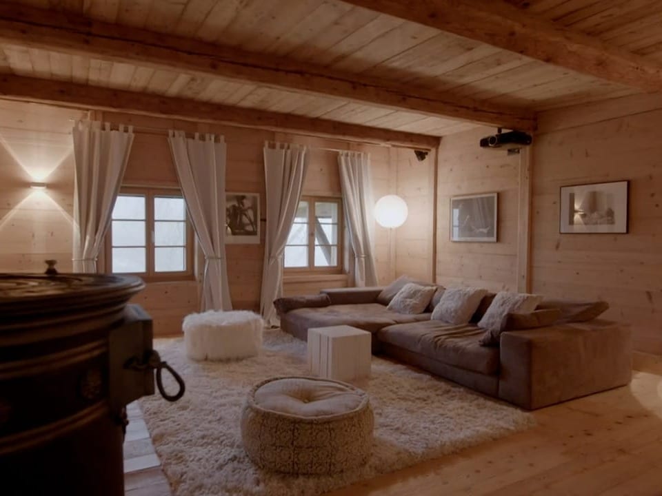 Ein Wohnzimmer mit weissem Teppich und grauen Sofa.
