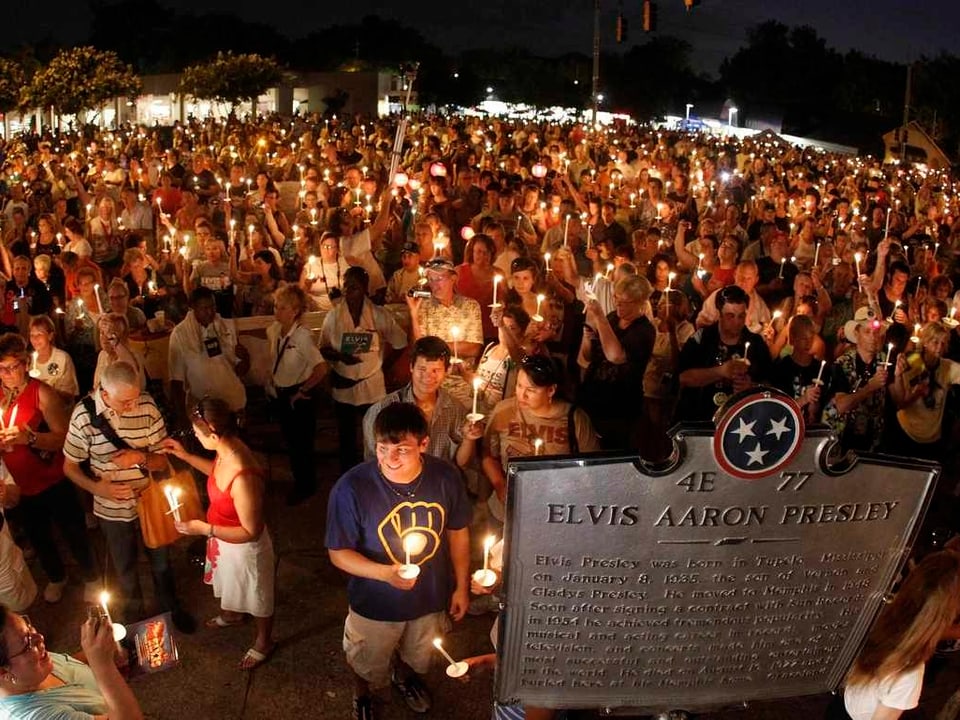 Tausende Menschen gedenken Presley mit Kerzen in der Hand 