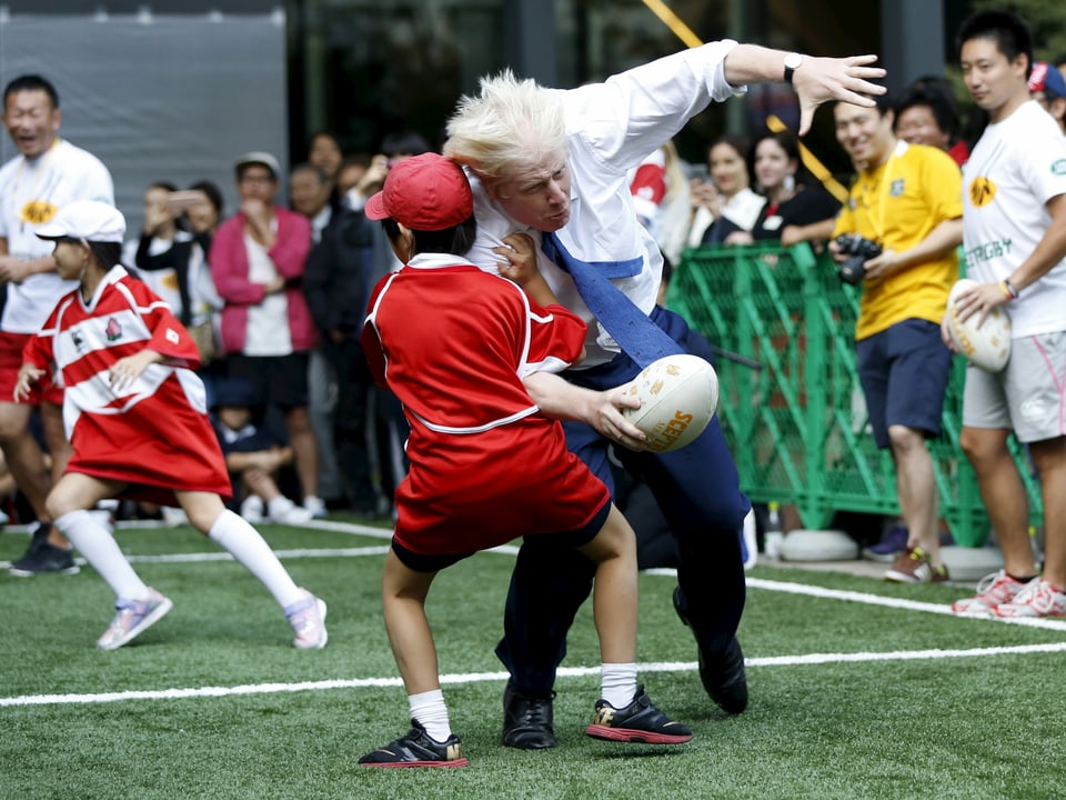 Johnson kämpft mit einem Jungen um den Rugby-Ball.