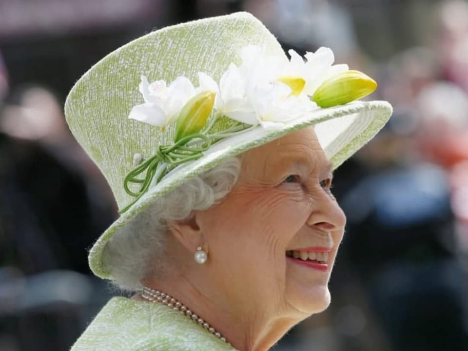 Queen Elizabeth in grünem Hut mit Blumen.