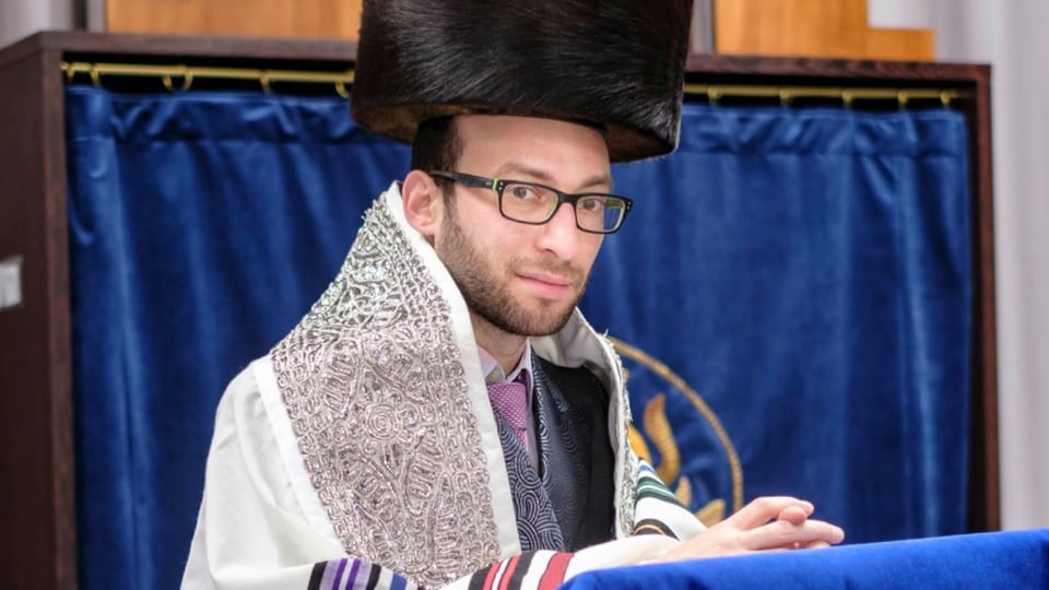 Ein jüdischer Rabbi mit Brille und einem Schtreimel auf dem Kopf.