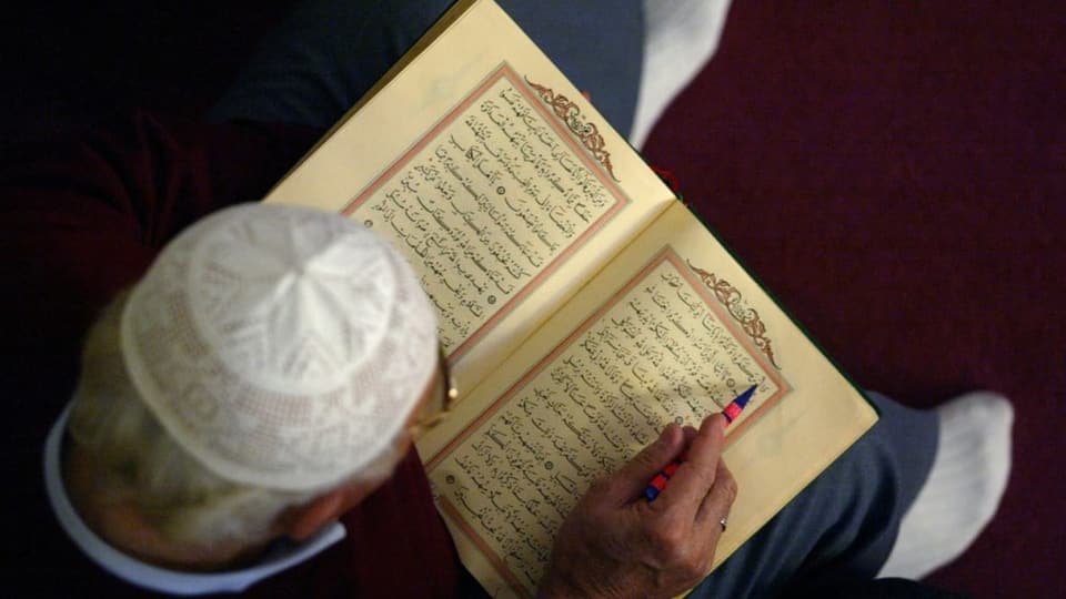 Ein Mann liest im Koran.