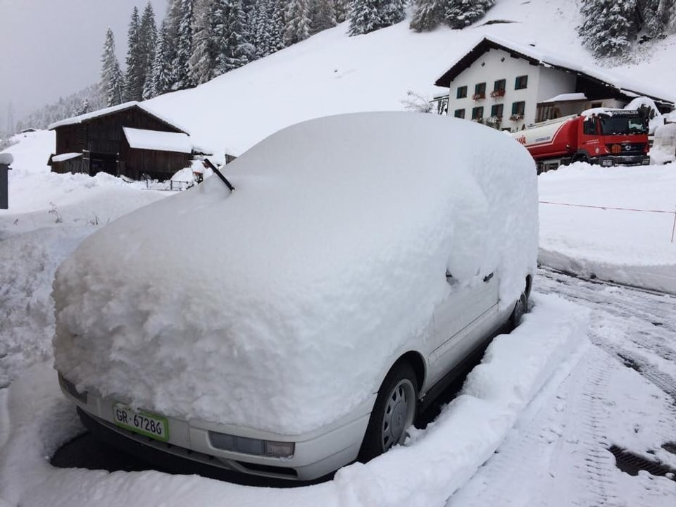 Ein Auto, dass unter dem vielen Schnee kaum mehr sichtbar ist.