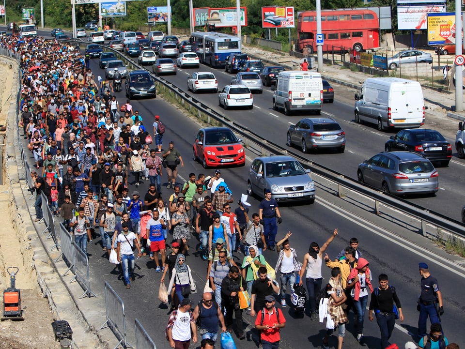 Ein Flüchtlingsstrom neben der Autobahn.