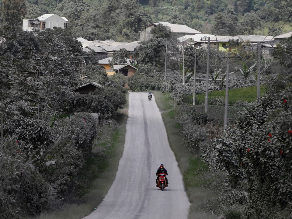 Dorfbewohner flüchten mit ihren Motorrädern aus einem Dorf. (reuters)
