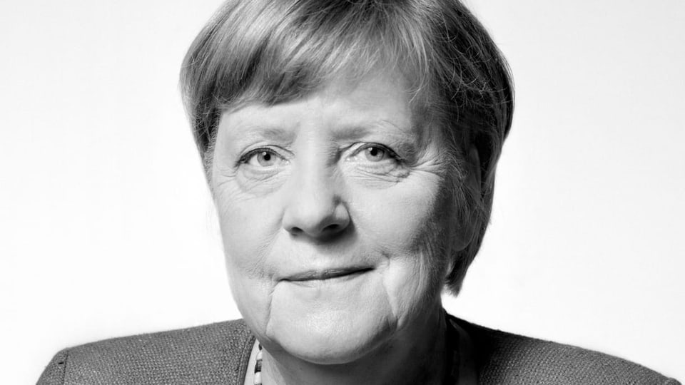Ältere Frau (Angela Merkel) blickt herausfordernd in Kamera