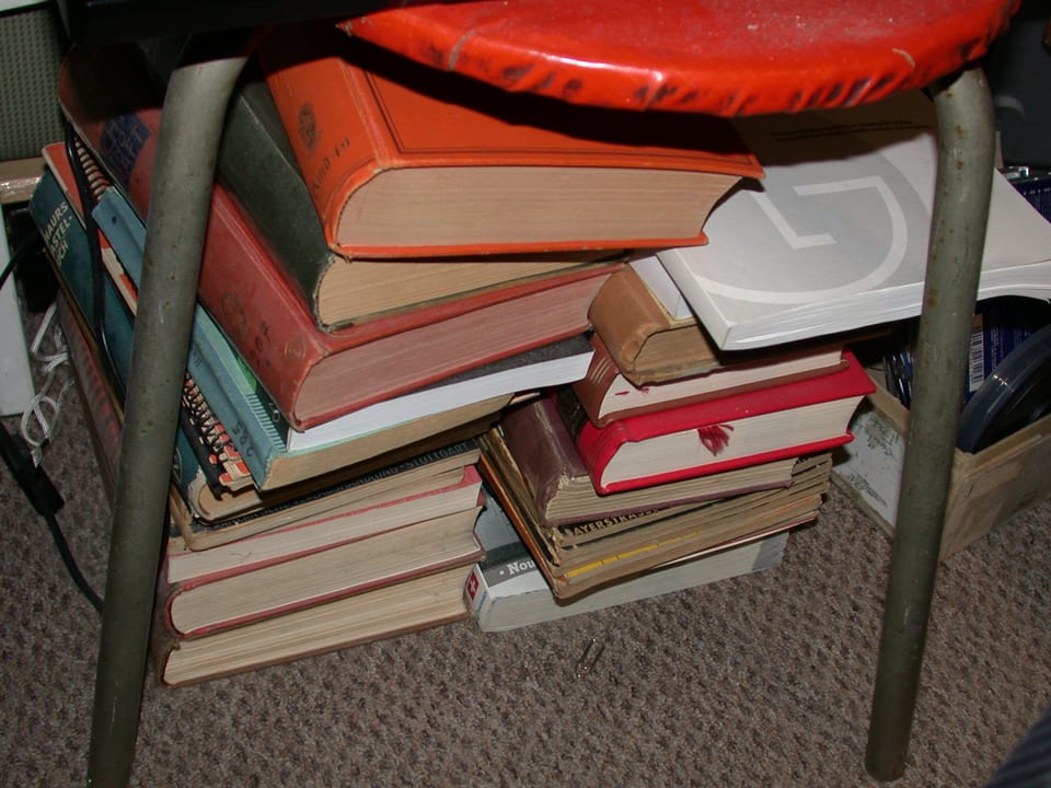 Bücher unter einem Hocker.
