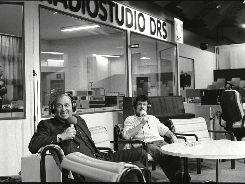 Zwei Männer mit Kopfhörer und Mikrofon sitzen im Studio an der MUBA.