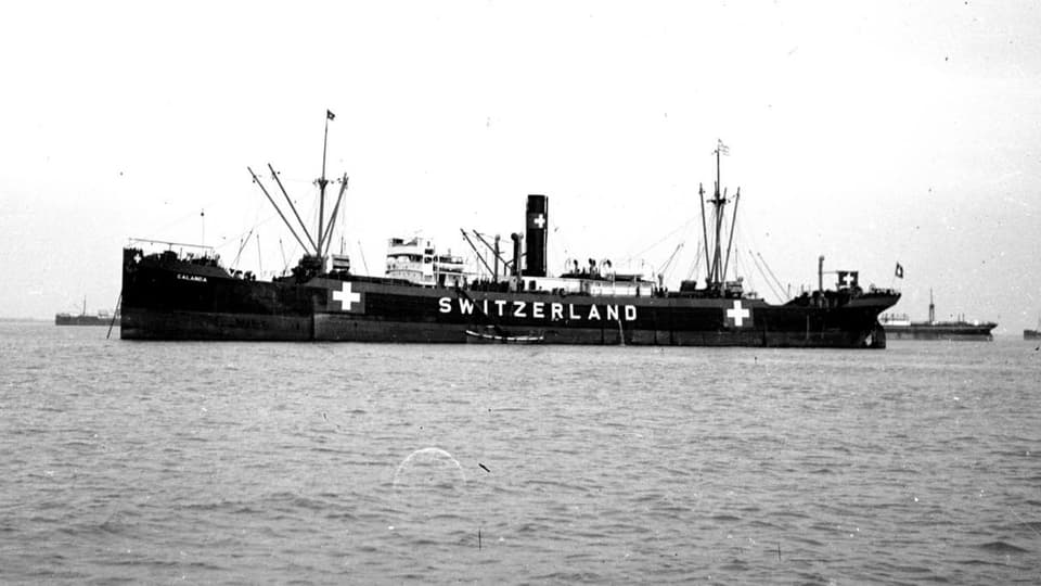 Schwarzweiss Aufnahme: Ein Schiff mit zwei Schweizer Kreuzen und dem Schriftzug «Switzerland».