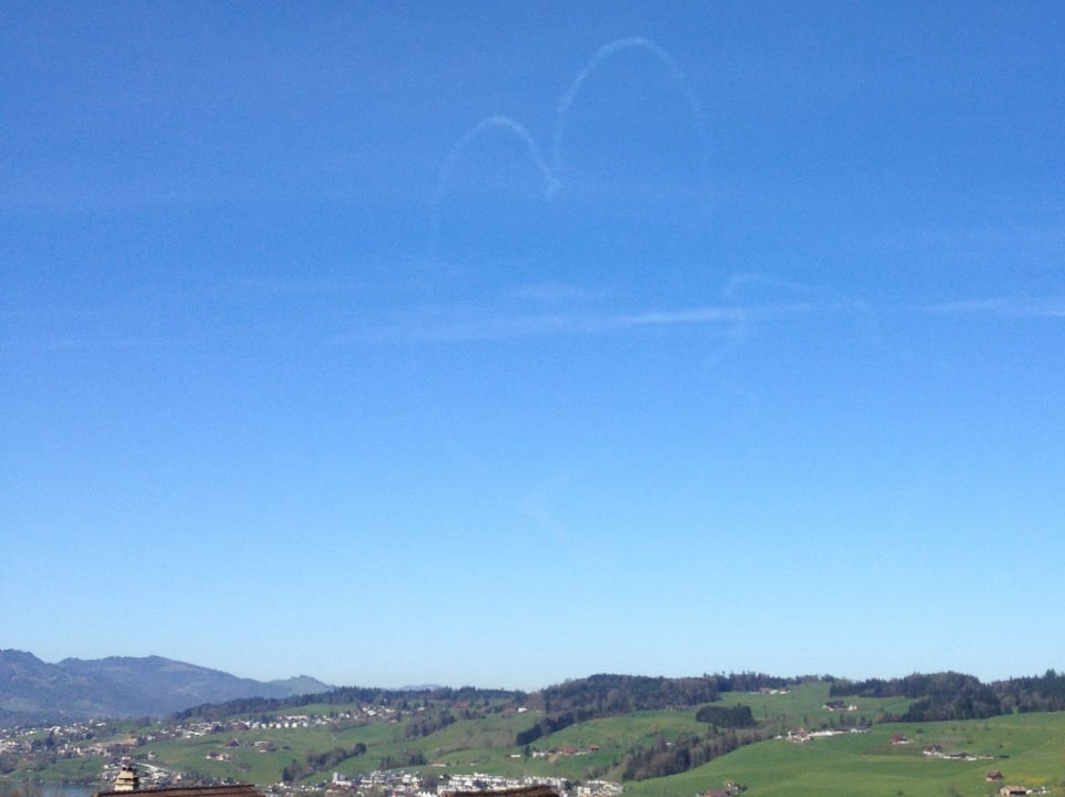 Blauer Himmel mit Flugzeug-Spur in Herzform