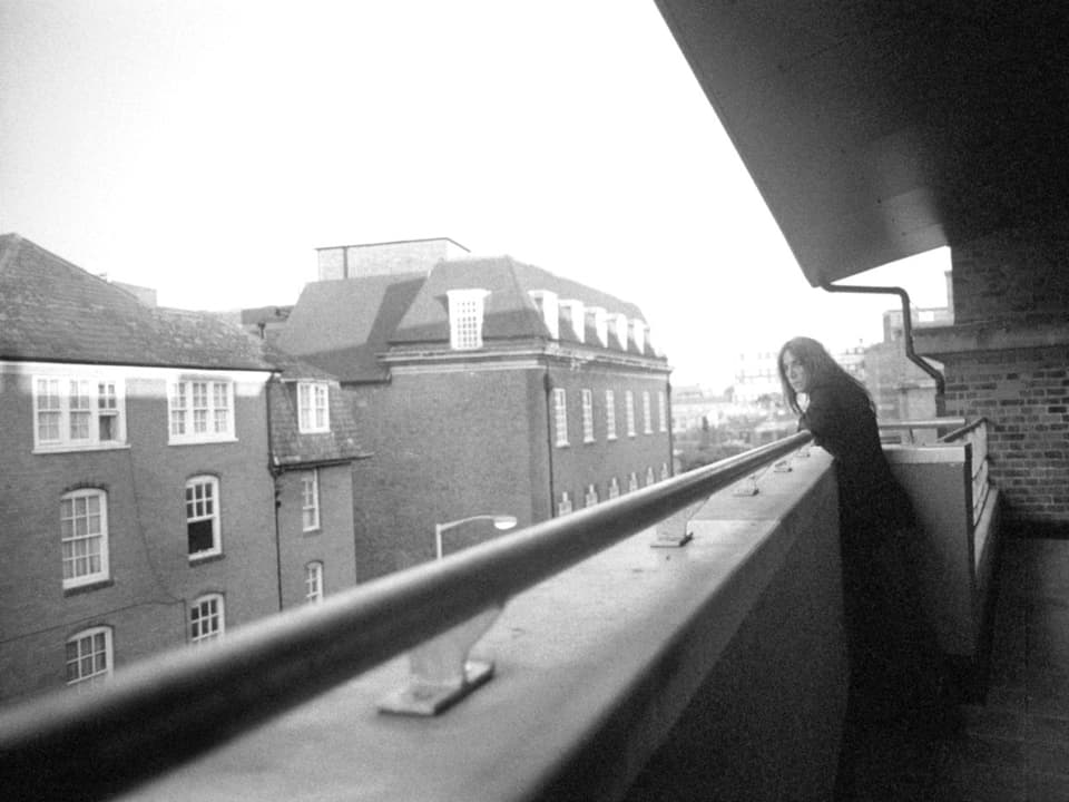 Patti Smith schaut von einem Balkon hinunter auf die Strasse.