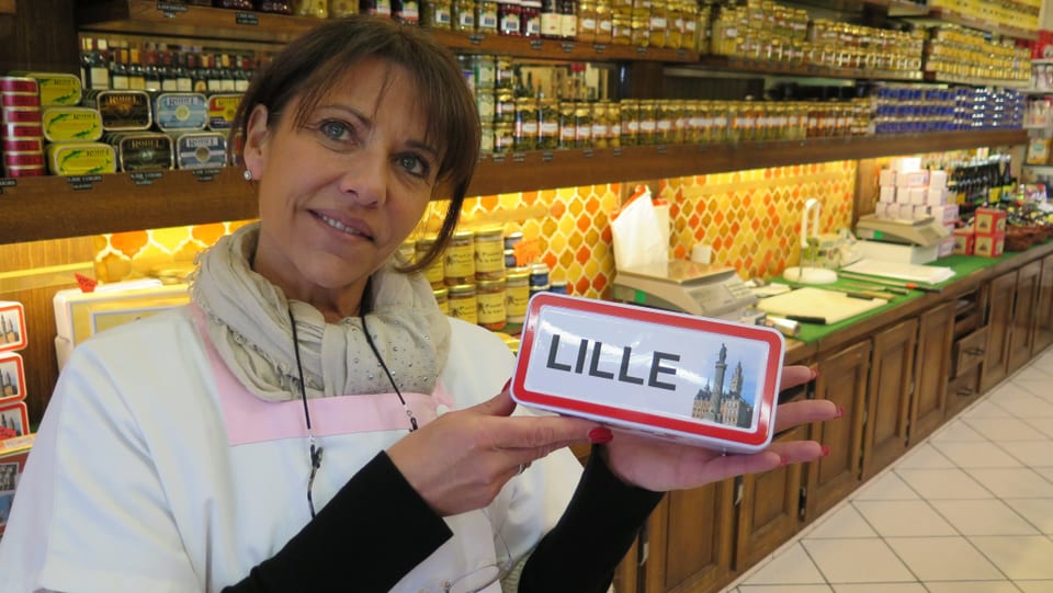 Coralie hät ein Souvenir mit der Aufschrift Lille hoch.