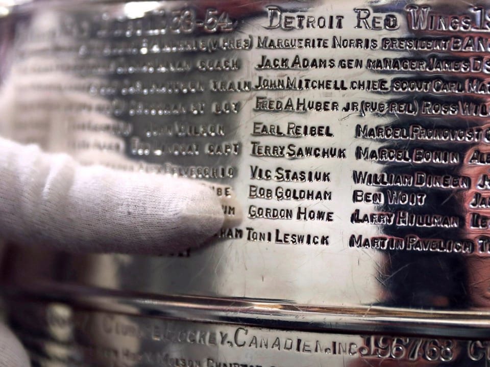 Ein Finger zeigt auf den Namen Gordie Howe auf der Stanley-Cup-Plakette.