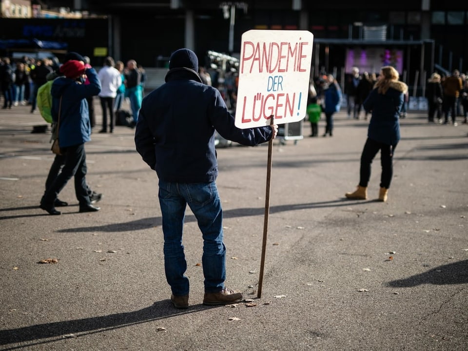 Ein Demonstrant hält ein Schild mit der Aufschrift Pandemie der Lügen.