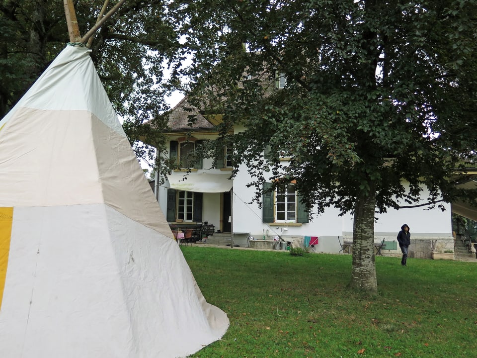 Im Vordergrund ein weisses Tipi-Zelt, im Hintergrund die Herrschaftsvilla Jolimont.