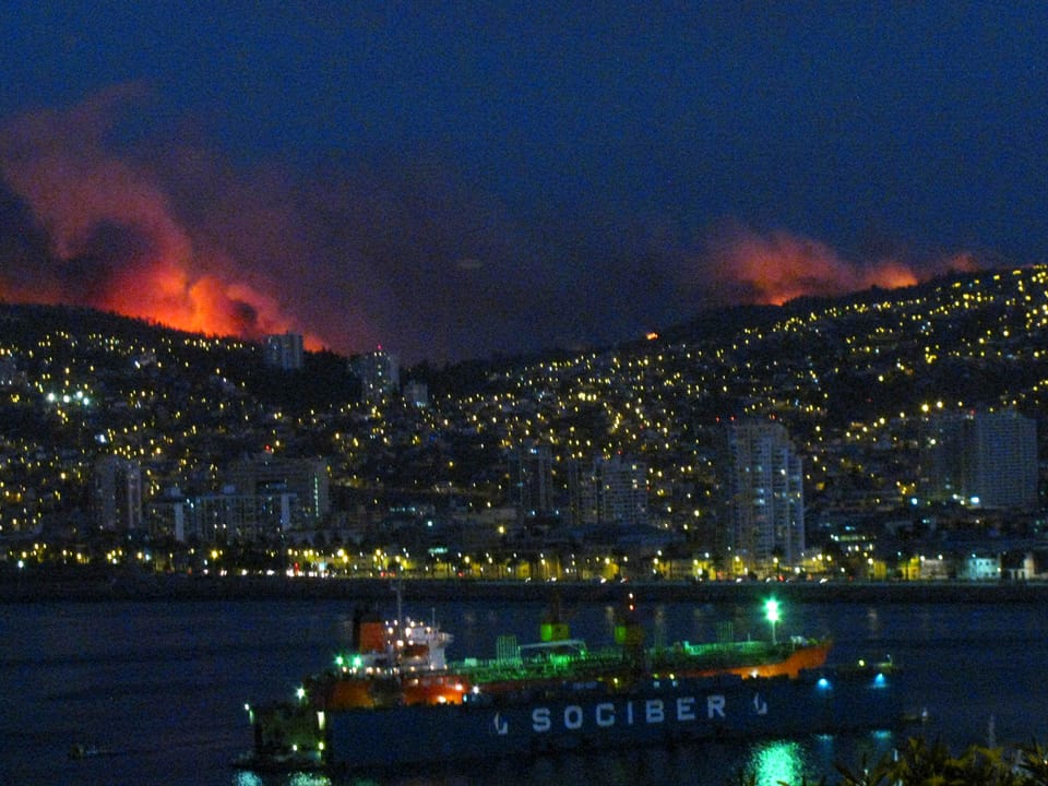 Hafenstadt in der Nacht, mit Bränden im Hintergrund