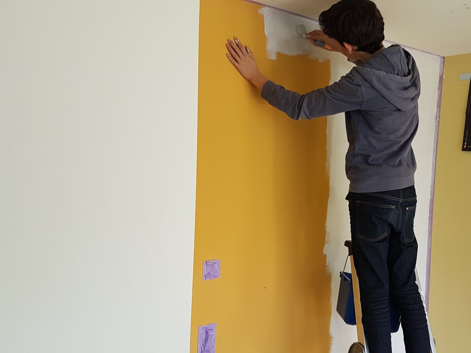 Liam streicht seine Wand