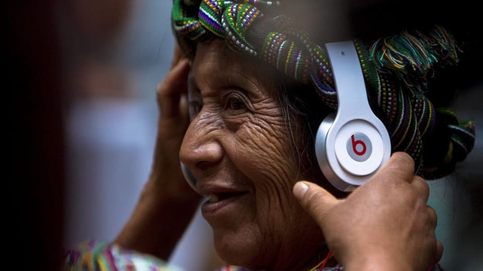 Eine Indigene mit Kopfhörern.