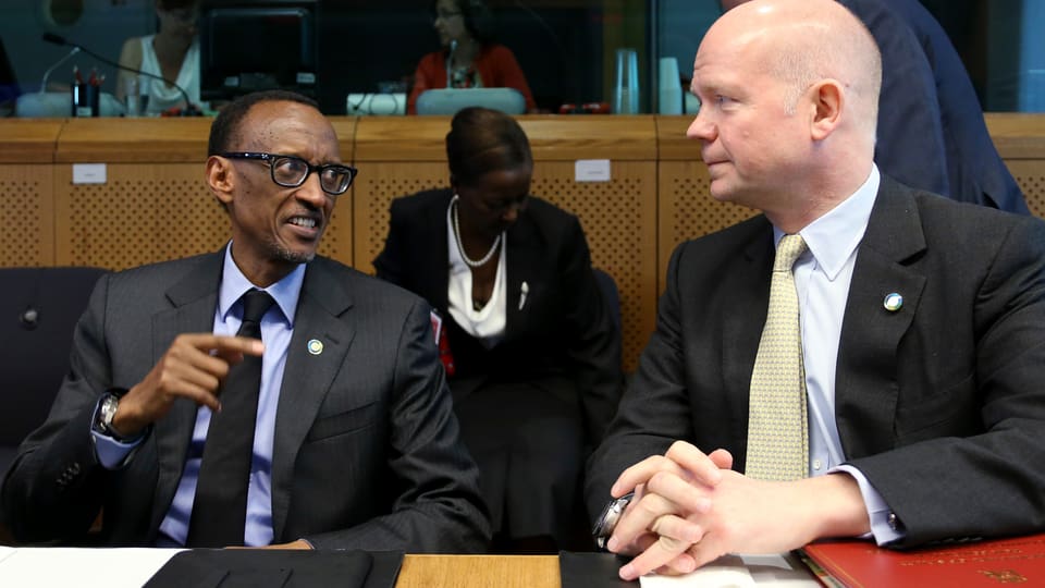 Kagame und Hague sitzen nebeneinander und sind in ein Gespräch vertieft.
