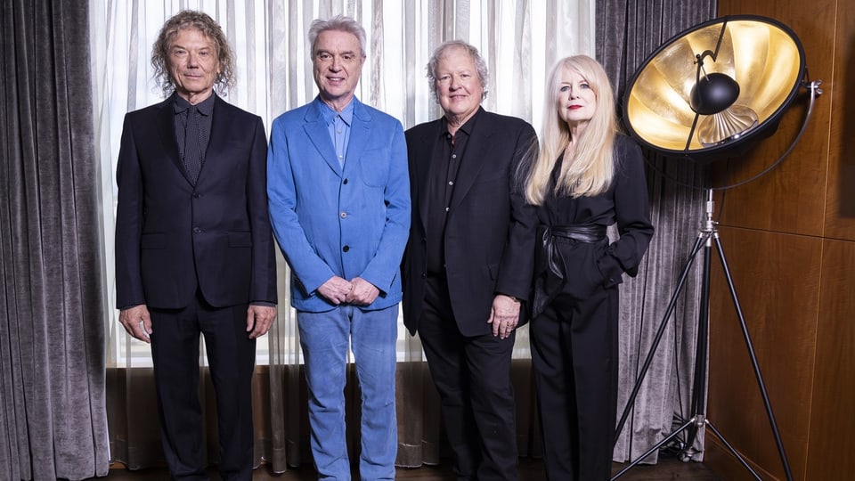 Die vier Mitglieder der Band «Talking Heads» wurden 2023 in formeller Kleidung vor geschlossenem Vorhang fotografiert.