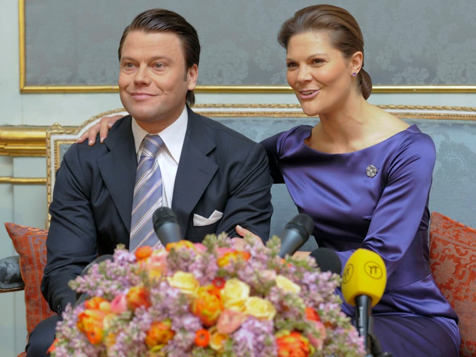Daniel Westling und Victoria hinter einem grossen Blumenstrauss sitzend.