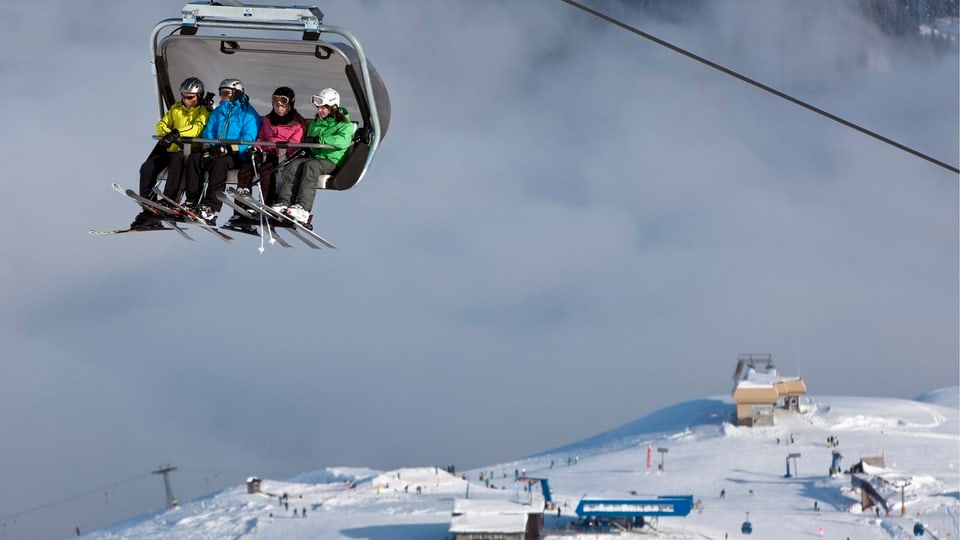 Skifahrer auf Sessellift