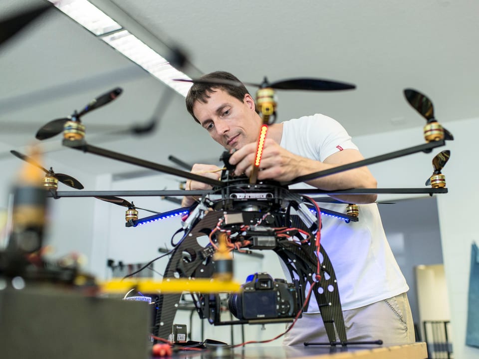 Ein Techniker schraubt an einer Drohne