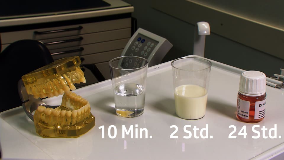 Künstliches Gebiss, daneben ein Glas Wasser, ein Glas kalte Milch und eine Zahnrettungsbox