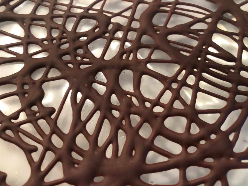 Auf einer Plastikfolie ist ein Muster aus Schokolade. 