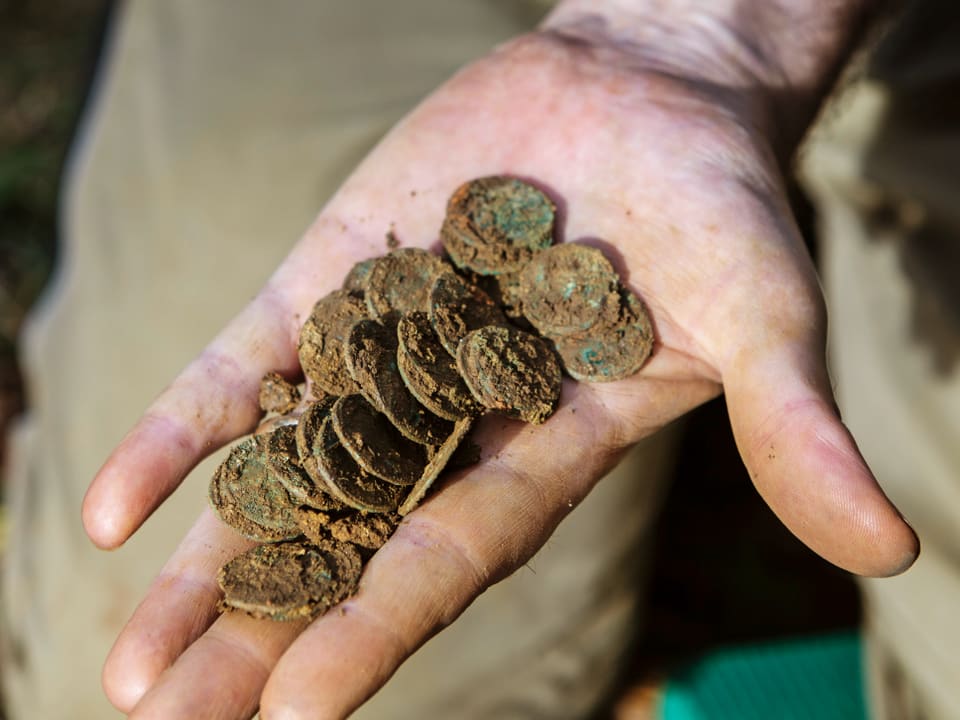 Dreckige Münzen auf einer Hand