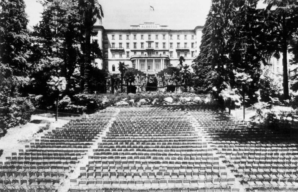 Black and white shot: rows of empty chairs in front of the hotel