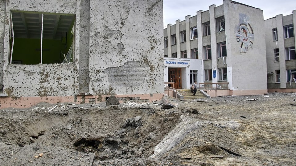 Zerbombte Schule mit Bombenkrater.