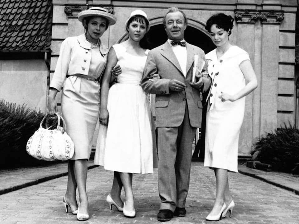 Ein Schauspieler posiert mit drei Frauen für die Kamera.