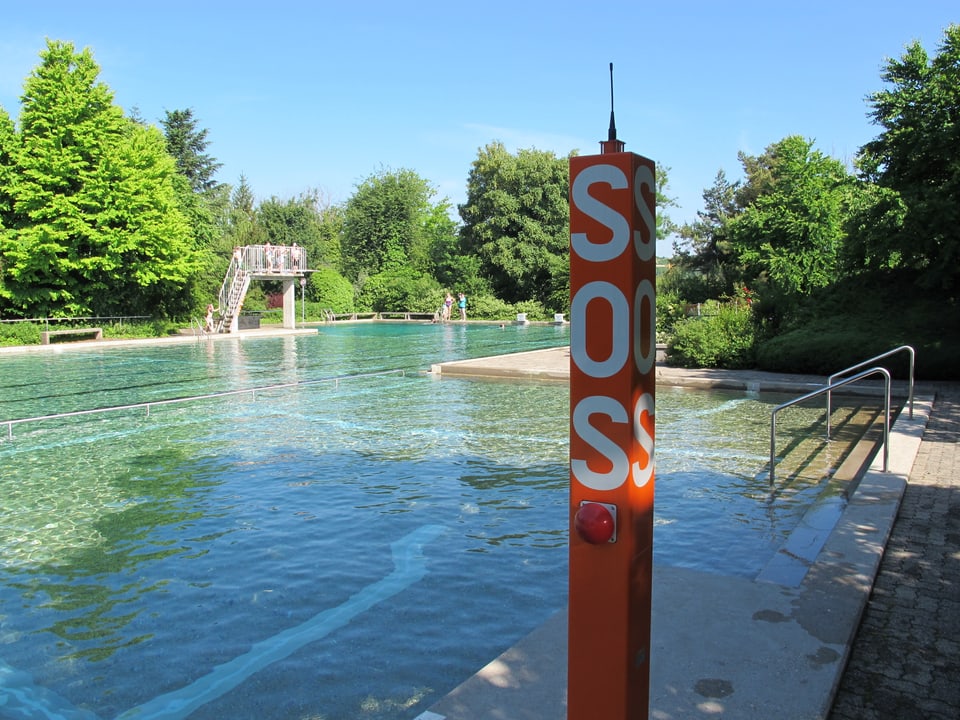 Blick ins Aussenbecken der Badi Rheinau, orange SOS-Säule