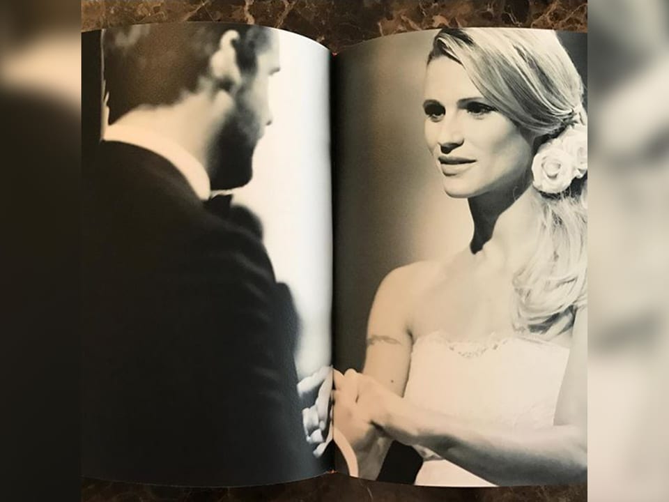 Ein aufgeschlagenes Fotoalbum. Darin ist ein Foto das Michelle und ihren Mann bei der Hochzeit zeigt. 