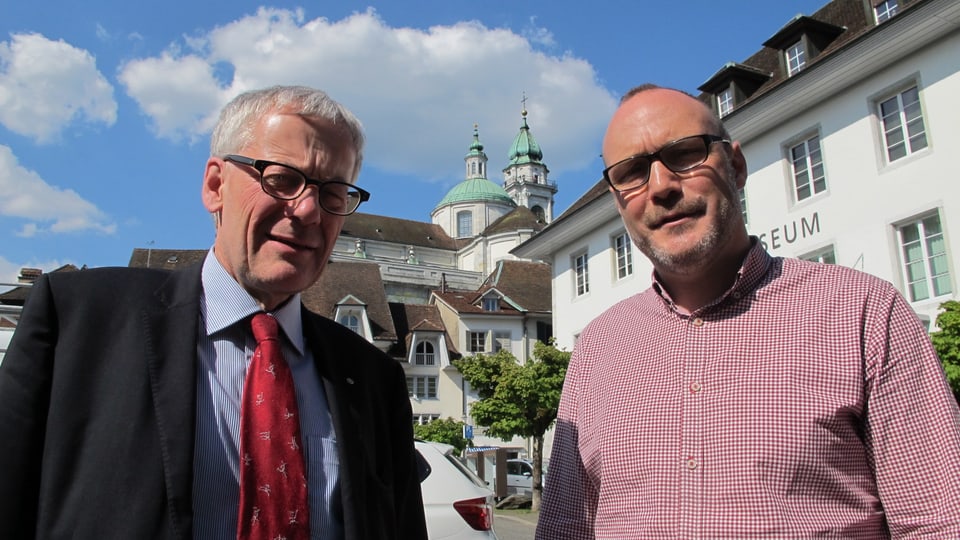 Kurt Fluri (steht links) und Hugo Schumacher stehen auf dem Klosterplatz in Solothurn, im Hintergrund die St. Ursenkathedrale.