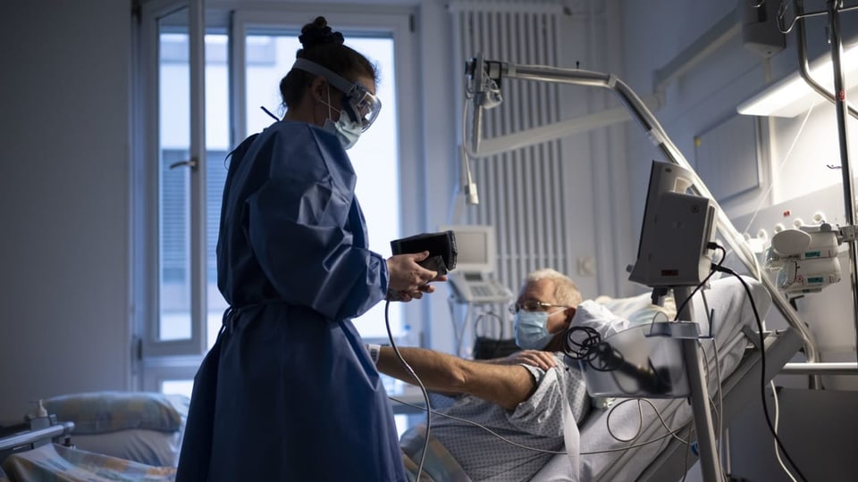 Eine Pflegerin behandelt einen Covid-Patienten im Spital.