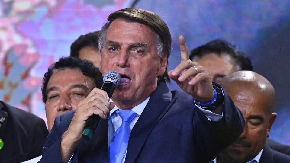 Jair Bolsonaro spricht mit einem Mikrofon in der Hand.