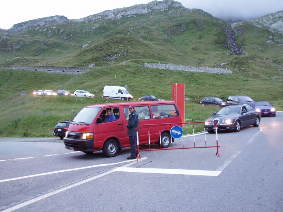 Ein roter Bus wird von einem Grenzwächter kontrolliert.
