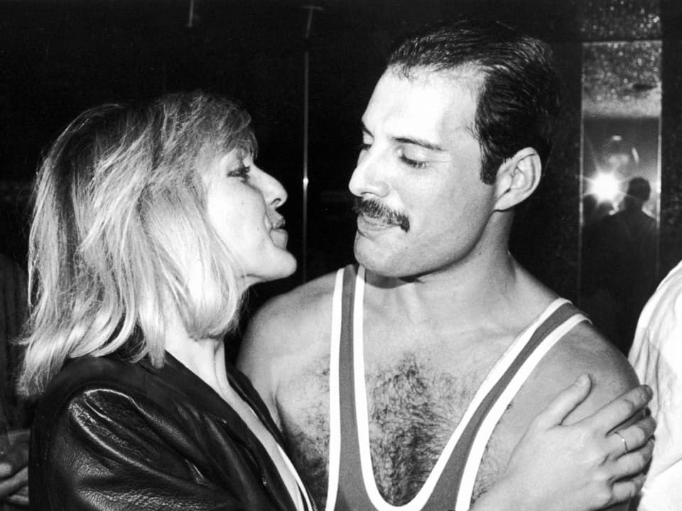 Mary Austin und Freddie Mercury halten sich im Arm.