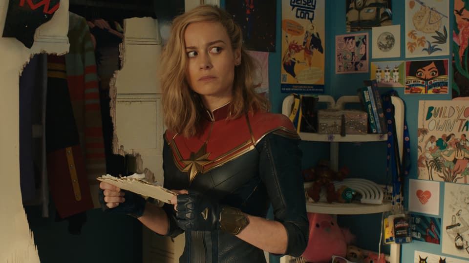 Brie Larson blickt als Captain Marvel verwirrt in die Kamera, nachdem sie ins Zimmer eines Teenagers geschleudert wurde.