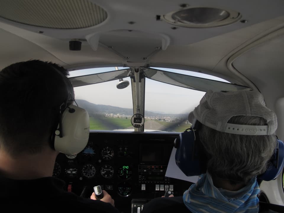 Blick aus der hinteren Reihe auf das Cockpit und die Landepiste.