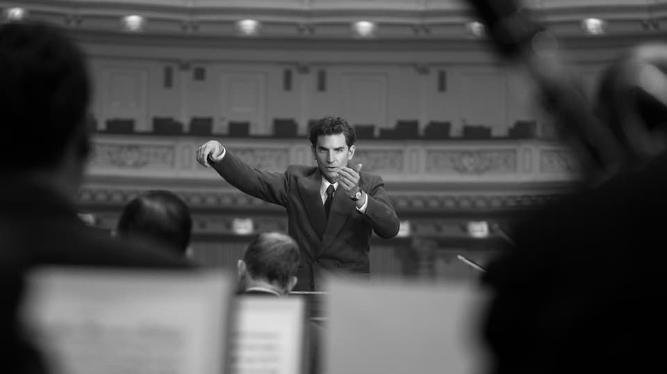 Schwaez-Weiss-Bild von  Bradley Cooper  bei Dirigieren in einem Konzerthaus