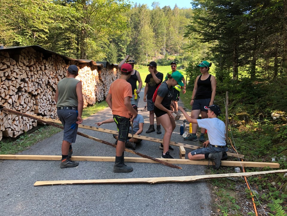 Kinder und Jugendliche arbeiten mit Holz auf einer Strasse