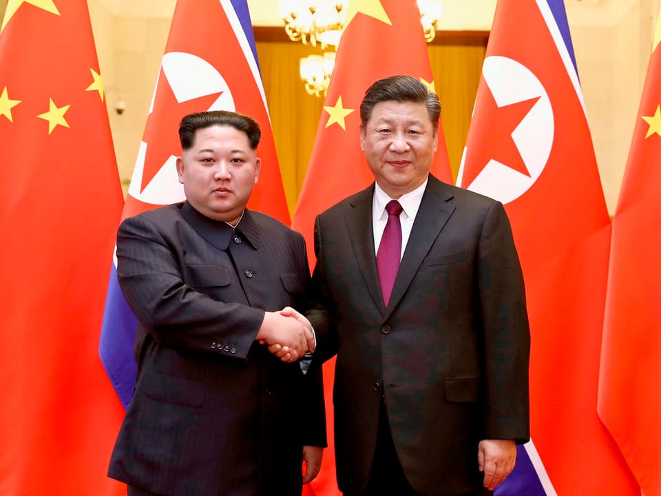 Kim und Xi geben sich die Hand.