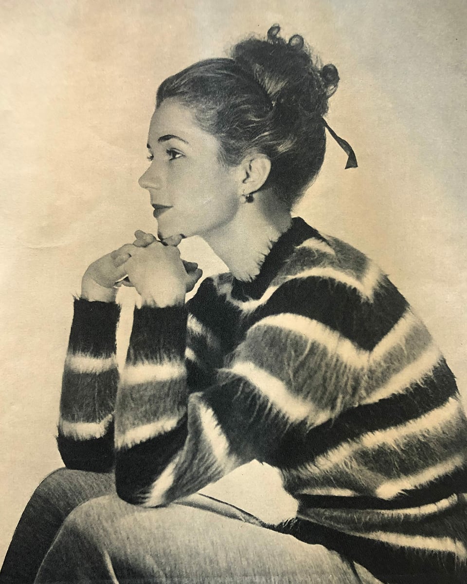 Junge Frau in gestreiftem Pullover sitzend. 