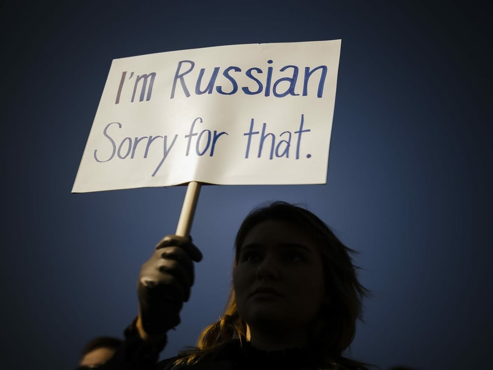 Eine Person hält ein Plakat mit der Aufschrift «I'm Russian – Sorry for that.».