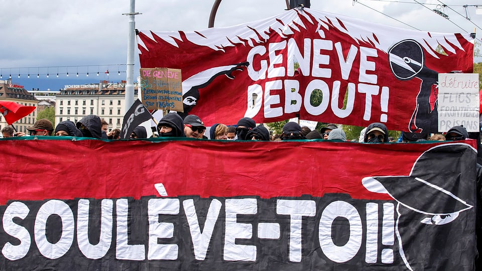 Demonstrationszug mit Transparenten in Genf.