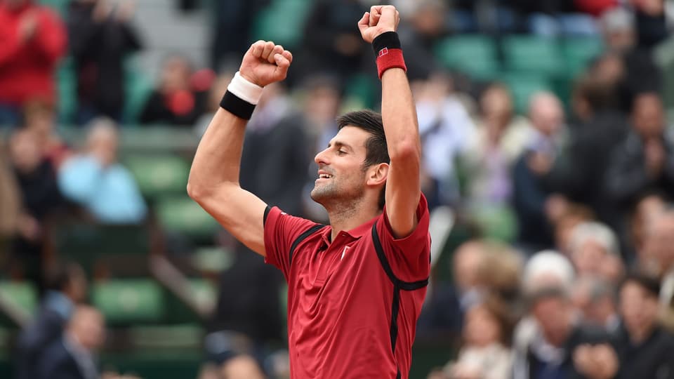 Novak Djokovic reisst beide Arme in die Höhe.